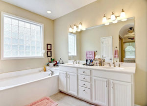 home bathroom with tub and double vanity